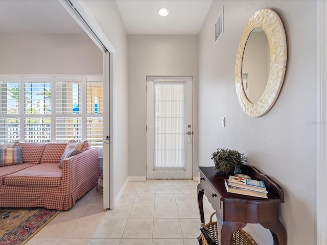 doorway featuring baseboards, visible vents, and light tile patterned floors