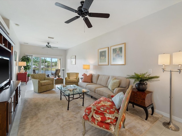 living area featuring light tile patterned floors, visible vents, a ceiling fan, and baseboards