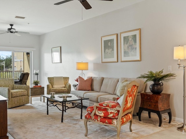living area featuring baseboards, visible vents, and ceiling fan
