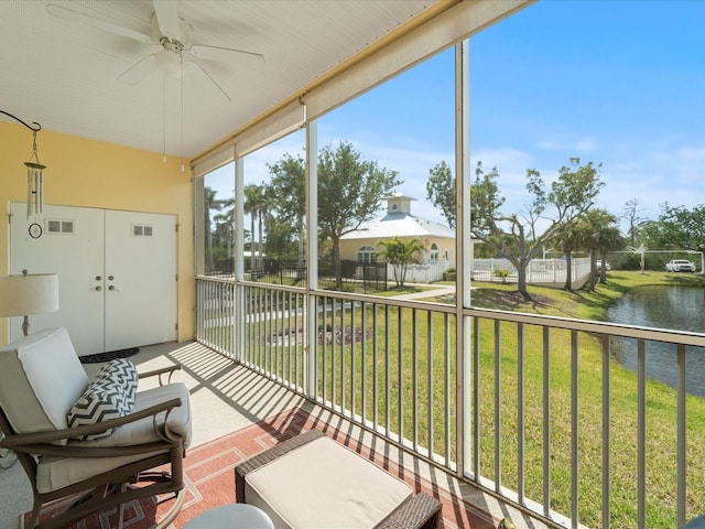 sunroom / solarium with visible vents, ceiling fan, and a water view