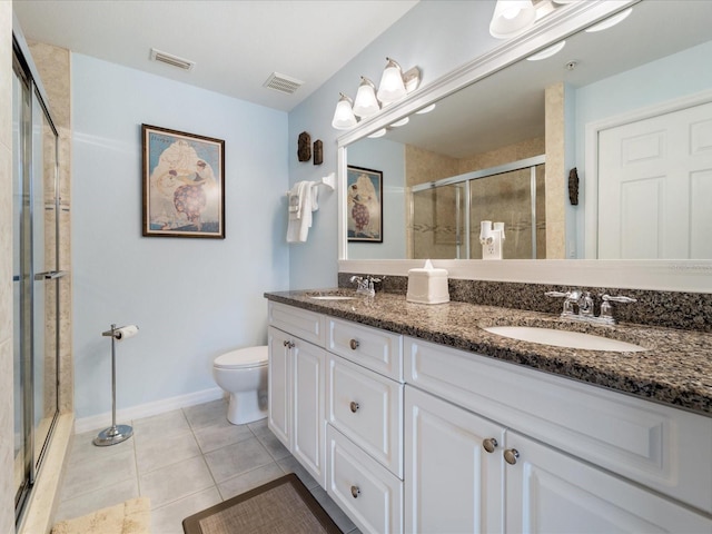 bathroom featuring toilet, a stall shower, a sink, and visible vents