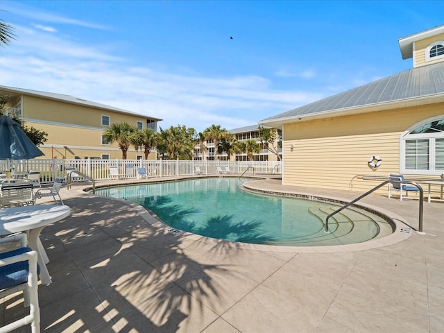 pool with a patio and fence