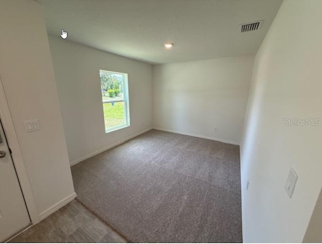 unfurnished room featuring carpet flooring, baseboards, and visible vents