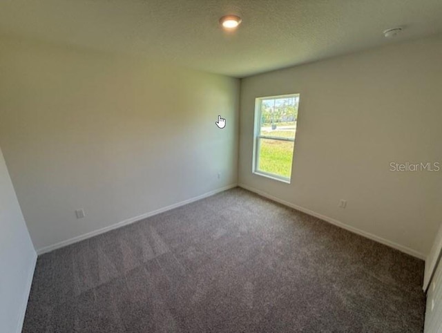carpeted spare room with baseboards