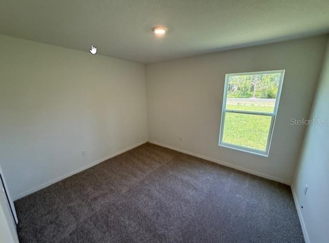 unfurnished room with carpet floors and baseboards