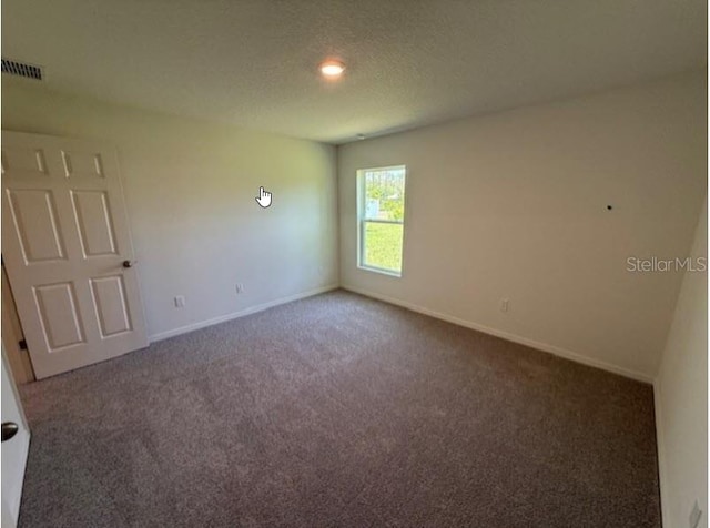 empty room featuring carpet floors, baseboards, and visible vents
