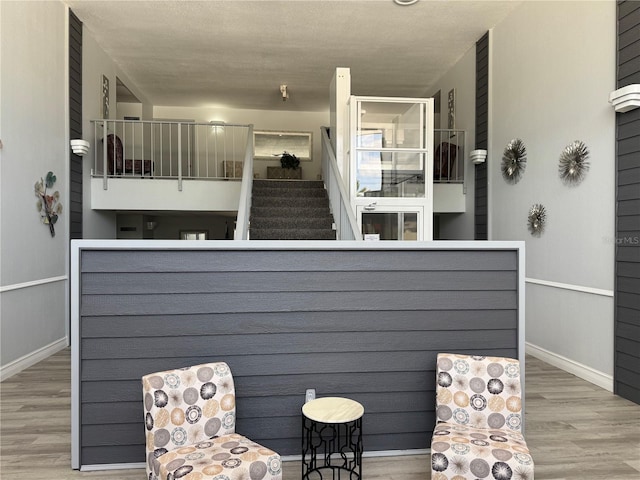 sitting room with baseboards and wood finished floors