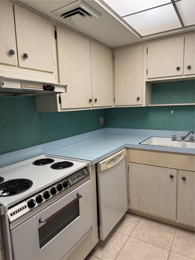 kitchen with visible vents, a sink, light countertops, white appliances, and light tile patterned flooring