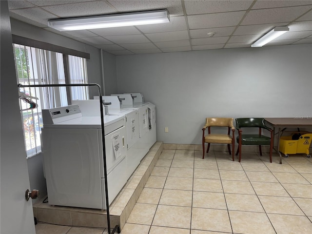 community laundry room featuring light tile patterned floors and washing machine and clothes dryer