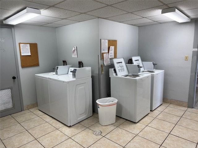 community laundry room featuring light tile patterned floors, washing machine and dryer, and visible vents