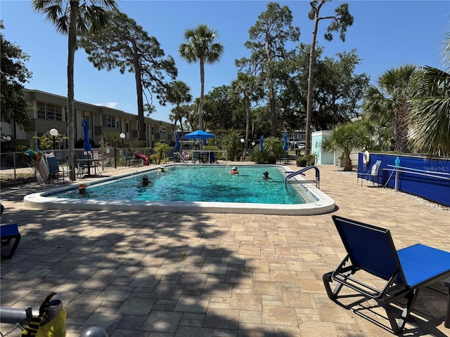 community pool featuring a patio and fence