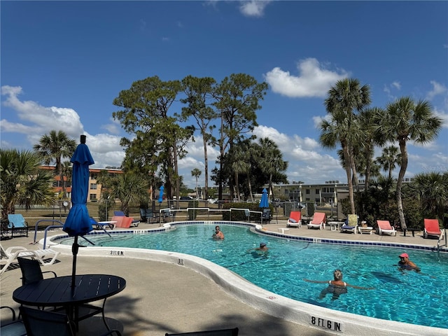 pool with fence and a patio area