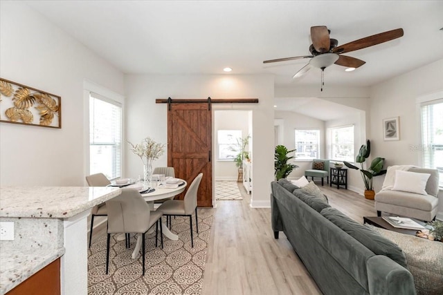 living room with recessed lighting, a ceiling fan, a barn door, and light wood-type flooring
