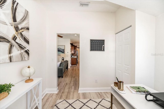 corridor featuring visible vents, light wood-type flooring, and baseboards