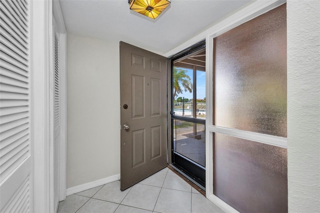 foyer entrance featuring baseboards and light tile patterned flooring