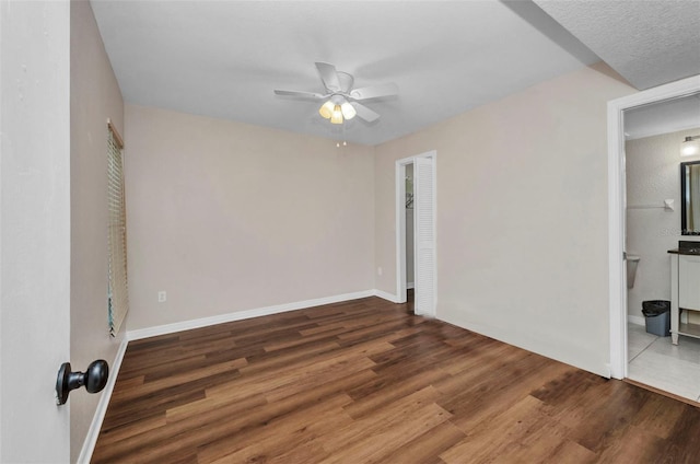 empty room featuring a ceiling fan, baseboards, and wood finished floors