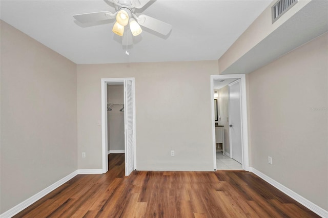 unfurnished bedroom featuring baseboards, visible vents, wood finished floors, and a closet