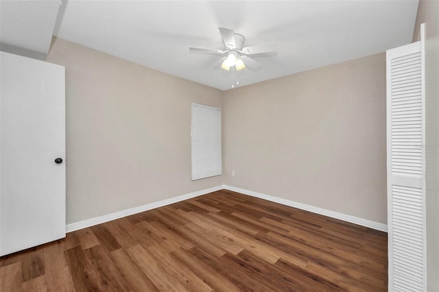 spare room featuring baseboards, ceiling fan, and wood finished floors