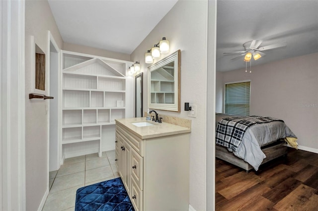 ensuite bathroom featuring connected bathroom, tile patterned flooring, vanity, a ceiling fan, and baseboards