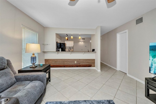 living room featuring visible vents, a ceiling fan, baseboards, and light tile patterned floors