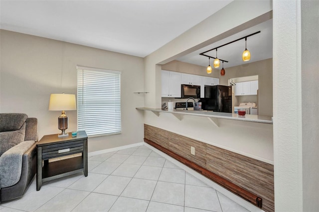interior space featuring white cabinets, light countertops, separate washer and dryer, baseboards, and black appliances
