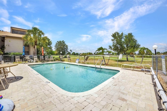 pool featuring fence and a patio area