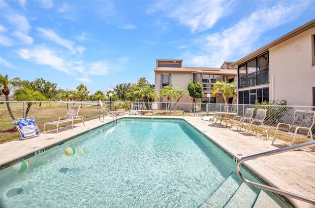 community pool featuring a patio and fence