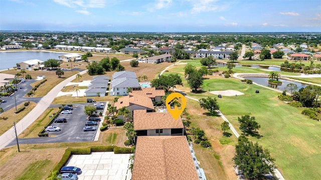 drone / aerial view featuring a water view, a residential view, and golf course view