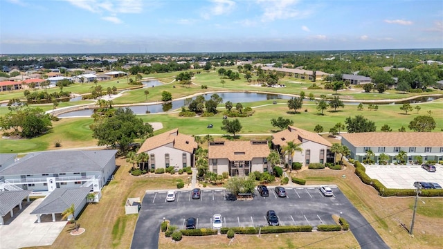 aerial view featuring a water view, view of golf course, and a residential view