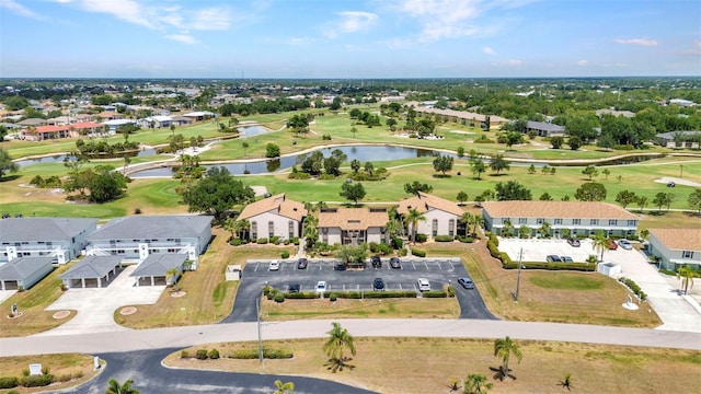 drone / aerial view with a residential view, view of golf course, and a water view