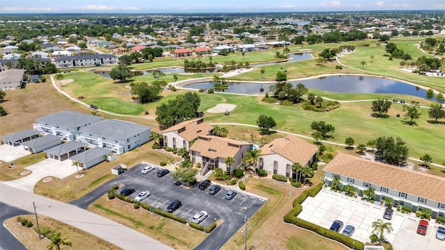drone / aerial view with a water view, view of golf course, and a residential view