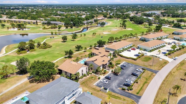 drone / aerial view with a water view, view of golf course, and a residential view