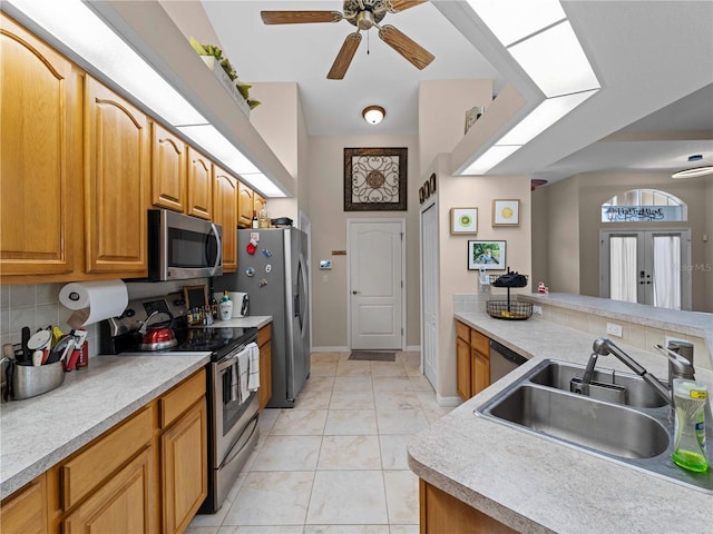 2288 Prague Ln, Punta Gorda, FL 33983 - kitchen featuring appliances with stainless steel finishes, a sink, light countertops, a ceiling fan, and tasteful backsplash