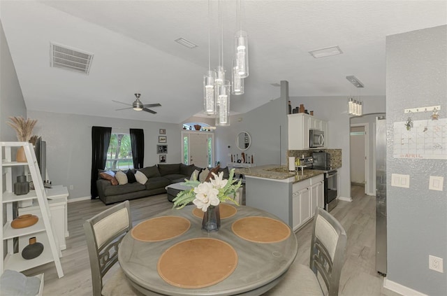 4129 Palisades Ave, North Port, FL 34287 - dining space with a ceiling fan, baseboards, vaulted ceiling, light wood-type flooring, and visible vents