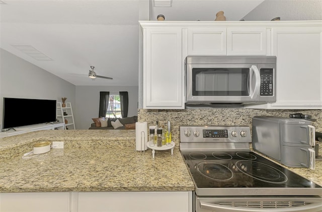 4129 Palisades Ave, North Port, FL 34287 - kitchen with appliances with stainless steel finishes, light stone countertops, vaulted ceiling, and white cabinetry