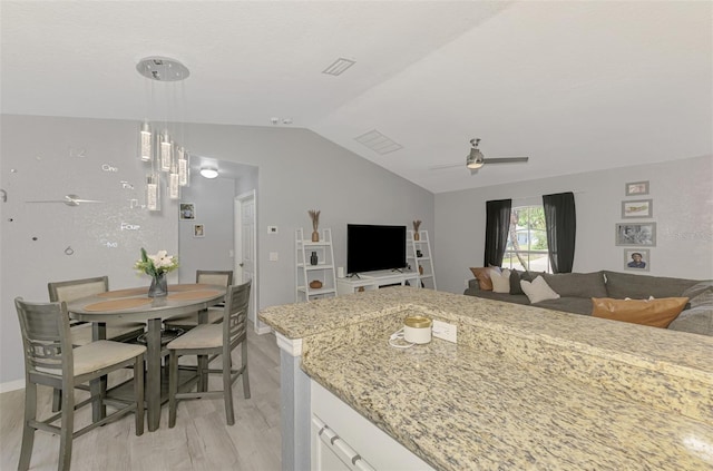 4129 Palisades Ave, North Port, FL 34287 - kitchen featuring light wood-style flooring, a ceiling fan, open floor plan, white cabinetry, and vaulted ceiling