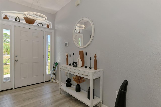 4129 Palisades Ave, North Port, FL 34287 - foyer with baseboards, a textured wall, light wood-type flooring, and a chandelier