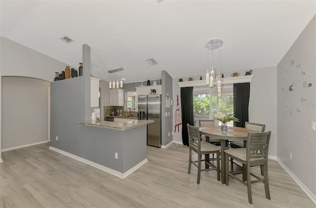 4129 Palisades Ave, North Port, FL 34287 - kitchen featuring stainless steel refrigerator with ice dispenser, light stone countertops, light wood-type flooring, a sink, and a notable chandelier