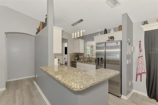 4129 Palisades Ave, North Port, FL 34287 - kitchen with light wood-type flooring, white cabinets, light stone counters, a sink, and stainless steel appliances