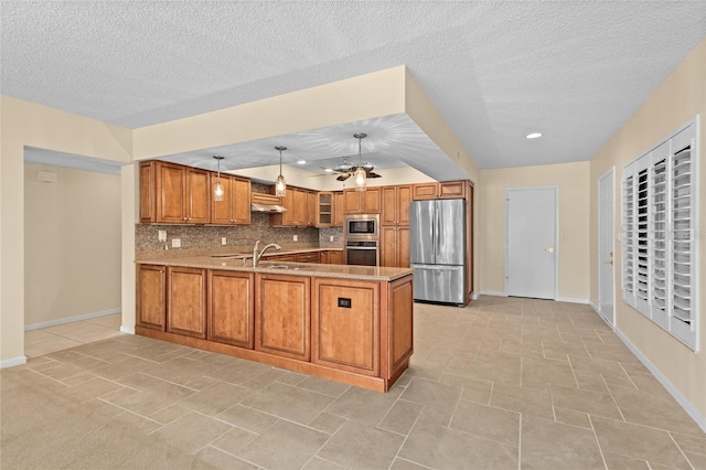 3230 Southshore Dr Unit 33A, Punta Gorda, FL 33955 - kitchen with appliances with stainless steel finishes, a sink, brown cabinets, a peninsula, and baseboards