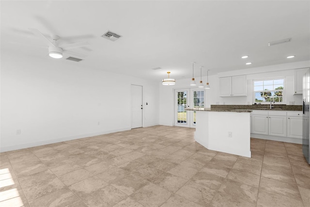 124 Rotonda Cir, Rotonda West, FL 33947 - kitchen with recessed lighting, a kitchen island, white cabinetry, visible vents, and french doors