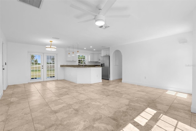 124 Rotonda Cir, Rotonda West, FL 33947 - unfurnished living room featuring a sink, ceiling fan, visible vents, baseboards, and arched walkways