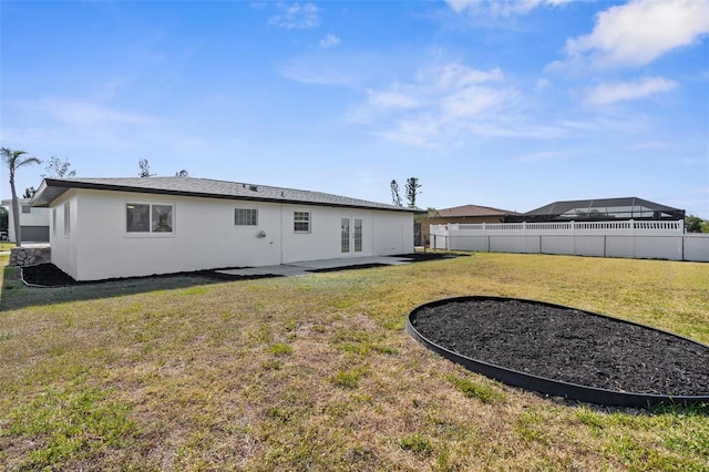 124 Rotonda Cir, Rotonda West, FL 33947 - rear view of property with stucco siding, a yard, fence, a patio, and french doors