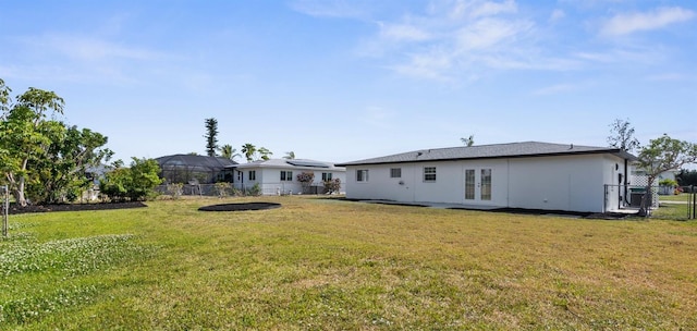 124 Rotonda Cir, Rotonda West, FL 33947 - rear view of house featuring a gate, french doors, a fenced backyard, and a yard