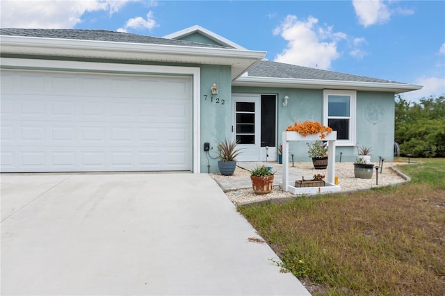 ranch-style home with an attached garage, roof with shingles, stucco siding, and concrete driveway