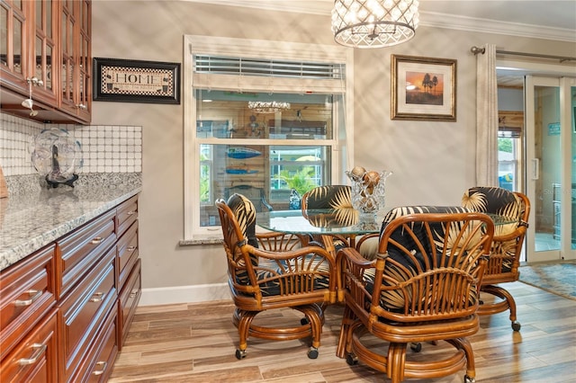 dining space with baseboards, ornamental molding, and light wood-type flooring
