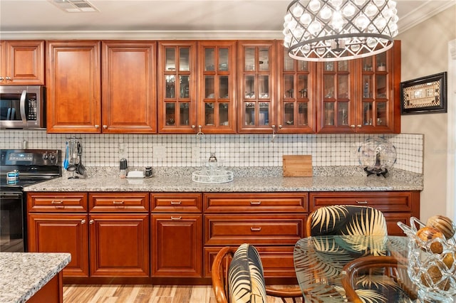 kitchen with visible vents, ornamental molding, decorative backsplash, black electric range oven, and stainless steel microwave