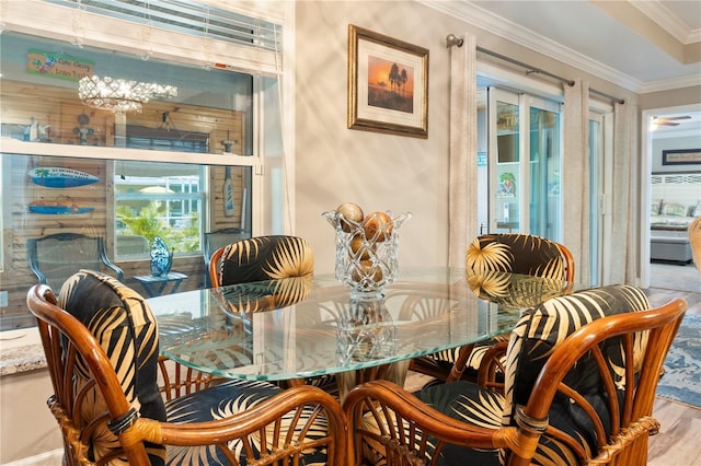 dining space with ornamental molding and wood finished floors