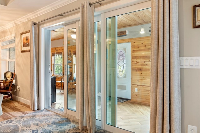 doorway to outside with crown molding, parquet floors, and baseboards