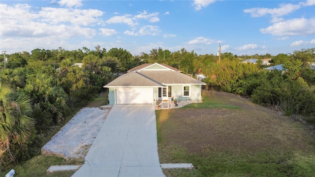 single story home featuring a front lawn, an attached garage, concrete driveway, and stucco siding